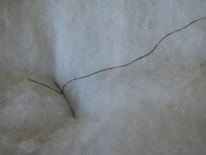 fixing the stuffing of a frumpy couch with needle and thread